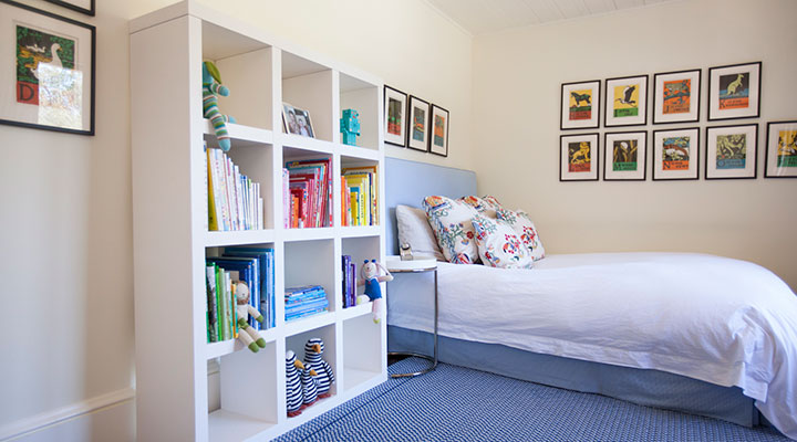 Organized childrens bedroom with toys and books in storage bins